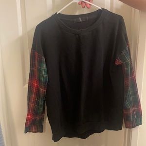 A black crew neck sweater with a square print in the arms. Warm but not too warm